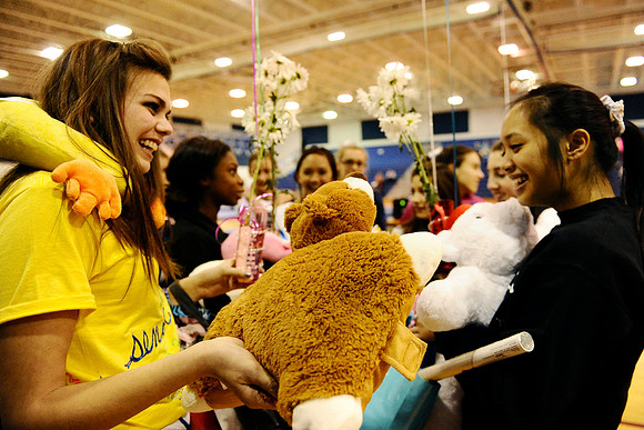 West Potomac senior Amanda Smith, left, shows fellow senior Lauren Pak a bear pillow she received as a senior gift from teammates after a gymnastics meet at West Potomac High School on January 3, 201