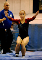 Jefferson senior Katya Davydova lands after her routine on the uneven bars, while coach Pete Novgrod watches, during a gymnastics meet at West Potomac High School on January 3, 2011. Novgrod coaches