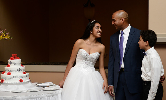 Alex, her father, and brother share a moment while waiting to take portraits.