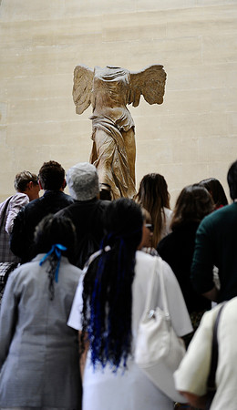 The "Winged Victory of Samothrace" stands over visitors at the top of the Daru staircase at the Louvre in Paris, France.July 16, 2012