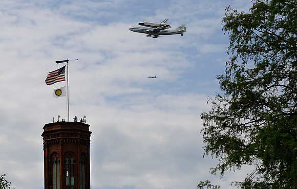 The space shuttle Discovery flies by the Smithsonian Castle on the back of a 747 plane on the way to Dulles Airport on April 17, 2012. Discovery will become part of the collection at the National Air