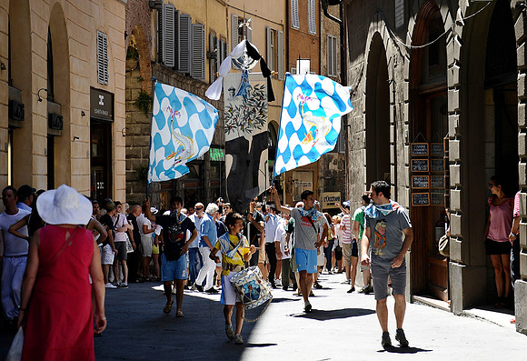 Residents of the Siena contrade of Onda (Wave) march through the streets in celebration of their recent win in Il Palio, a twice-yearly horse race held in the town square. The winners parade their fla